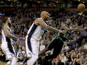Boston Celtics guard Terry Rozier (12) drives to the basket ahead of Orlando Magic forward Marreese Speights, center, and D.J. Augustin, left, during the first half of an NBA basketball game in Boston, Friday, Nov. 24, 2017. (AP Photo/Mary Schwalm)