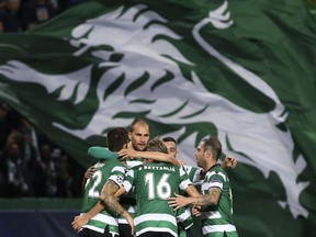 Sporting's Bas Dost, 2nd left, celebrates with team mates after scoring his side's opening goal during a Champions League, Group D soccer match between Sporting CP and Olympiakos at the Alvalade stadium in Lisbon, Wednesday Nov. 22, 2017. (AP Photo/Armando Franca)
