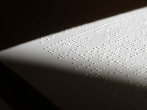 In this Tuesday, Oct. 17, 2017 photo a page of a braille book rests on a shelf at the National Braille Press in Boston. The Boston-based organization has been a leading force for braille literacy in the U.S., since its founding as a weekly newspaper for the blind in 1927. But it is now confronting a record low literacy in the writing system for the blind as it marks its 90th birthday this year.  (AP Photo/Steven Senne)