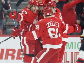 Detroit Red Wings left wing David Booth (17) celebrates with teammates Luke Glendening (41), Stefan Noesen (23) and Xavier Ouellet (61) during the first period of an NHL hockey game against the New Jersey Devils, Saturday, Nov. 25, 2017, in Detroit. (AP Photo/Duane Burleson)