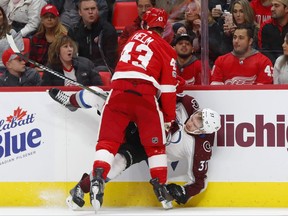 Detroit Red Wings left wing Darren Helm (43) checks Colorado Avalanche left wing J.T. Compher (37) in the first period of an NHL hockey game Sunday, Nov. 19, 2017, in Detroit. (AP Photo/Paul Sancya)