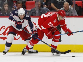 Columbus Blue Jackets defenseman Jack Johnson (7) and Detroit Red Wings left wing Andreas Athanasiou (72) battle for the puck in the second period of an NHL hockey game, Saturday, Nov. 11, 2017, in Detroit. (AP Photo/Paul Sancya)
