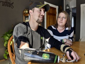 In this Feb. 25, 2014, photo, Little Falls, Minn., resident Jamie Houdek, with his wife, Lisa, at his side, talks about his recovery after he lost his right hand to a corn picker in November 2013 on the 60-acre hobby farm where he raises beef cattle. The nation's growing embrace of small-scale production of local and organic crops is leading to more farm injuries and deaths among amateur growers. Experts say some novices have little appreciation of the occupation's dangers.  (Kimm Anderson /St. Cloud Times via AP)