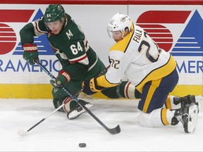 Minnesota Wild's Mikael Granlund, left, of Finland, and Nashville Predators' Kevin Fiala of Switzerland compete for the puck after colliding in the first period of an NHL hockey game Thursday, Nov. 16, 2017 in St. Paul, Minn. (AP Photo/Jim Mone)