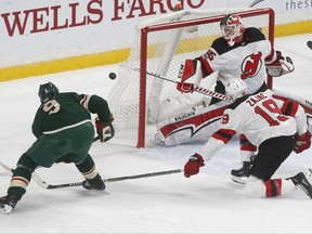 New Jersey Devils goalie Cory Schneider, right, stops a shot by Minnesota Wild's Mikko Koivu, of Finland, in the first period of an NHL hockey game Monday, Nov. 20, 2017, in St. Paul, Minn. (AP Photo/Jim Mone)