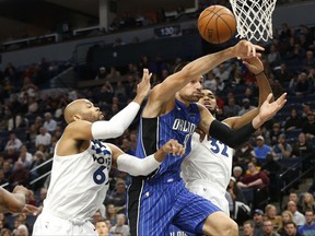Orlando Magic's Nikola Vucevic, center, of Montenegro, breaks up a play by Minnesota Timberwolves' Taj Gibson, left, and Karl-Anthony Towns in the first half of an NBA basketball game Wednesday, Nov. 22, 2017, in Minneapolis. (AP Photo/Jim Mone)