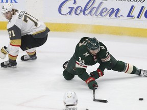 Minnesota Wild's Matt Dumba (24) tries to gain control of the puck as Vegas Golden Knights' William Karlsson (71) skates behind him in the first period of an NHL hockey game Thursday, Nov. 30, 2017, in St. Paul, Minn. (AP Photo/Stacy Bengs)
