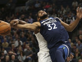 Minnesota Timberwolves center Karl-Anthony Towns (32) gets tangled up with Charlotte Hornets center Dwight Howard, left, in the first half of an NBA basketball game, Sunday, Nov. 5, 2017, in Minneapolis. (AP Photo/Stacy Bengs)