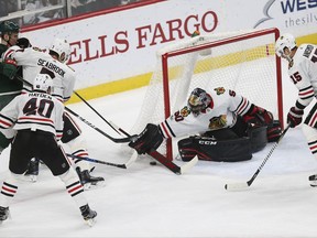 Chicago Blackhawks' goalie Corey Crawford (50) reaches out to stop the puck in the first period of an NHL hockey game against the Minnesota Wild, Saturday, Nov. 4, 2017, in St. Paul, Minn. Chicago won 2-0. (AP Photo/Stacy Bengs)