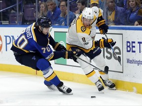 St. Louis Blues' Oskar Sundqvist, of Sweden, left, and Nashville Predators' Kyle Turris, right, chase after a loose puck during the first period of an NHL hockey game Friday, Nov. 24, 2017, in St. Louis. (AP Photo/Jeff Roberson)