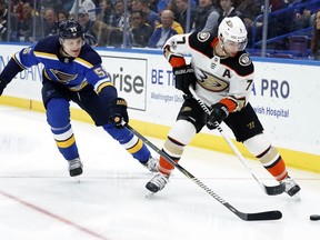 Anaheim Ducks' Andrew Cogliano, right, and St. Louis Blues' Colton Parayko reach for the puck during the first period of an NHL hockey game Wednesday, Nov. 29, 2017, in St. Louis. (AP Photo/Jeff Roberson)