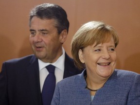 German Chancellor Angela Merkel, right, and Vice Chancellor and Foreign Minister Sigmar Gabriel, left, arrive for a cabinet meeting of the German government at the chancellery in Berlin, Wednesday, Nov. 22, 2017. (AP Photo/Markus Schreiber)