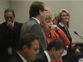 German Chancellor Angela Merkel, center right in red, talks to chairman of the German Christian Social Union state group, Alexander Dobrindt, center left, as she arrives for a faction meeting of her Christian parties' bloc at the Reichstag building in Berlin, Monday, Nov. 20, 2017.  (AP Photo/Markus Schreiber)