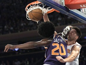 New York Knicks forward Doug McDermott, right, dunks the ball over Phoenix Suns forward Josh Jackson (20) during the second quarter of an NBA basketball game Friday, Nov. 3, 2017, at Madison Square Garden in New York. (AP Photo/Bill Kostroun)
