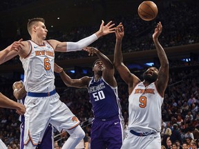 New York Knicks' Kristaps Porzingis, left, and Kyle O'Quinn (9) compete for the ball with Sacramento Kings' Zach Randolph during the first half of a NBA basketball game at Madison Square Garden in New York, Saturday, Nov. 11, 2017. (AP Photo/Andres Kudacki)