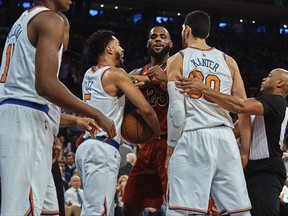 Cleveland Cavaliers' LeBron James, center, discusses with New York Knicks' Enes Kanter, center right, and Courtney Lee, center left, during the first half of a NBA basketball game at Madison Square Garden in New York, Monday, Nov. 13, 2017. (AP Photo/Andres Kudacki)
