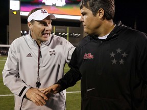 Mississippi State head coach Dan Mullen, left, and Mississippi head coach Matt Luke wish each other good luck prior to the start of an NCAA college football game in Starkville, Miss., Thursday, Nov. 23, 2017. (AP Photo/Rogelio V. Solis)