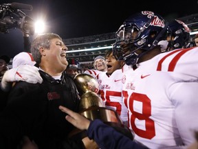 Mississippi coach Matt Luke, left, celebrates with players following their 31-28 win over Mississippi State in the Egg Bowl NCAA college football game in Starkville, Miss., Thursday, Nov. 23, 2017. (AP Photo/Rogelio V. Solis)