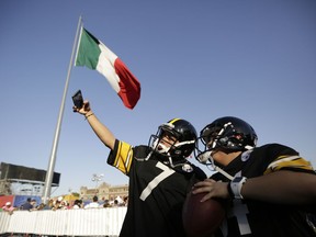 Fans pose wearing Pittsburgh Steelers uniforms during NFL football's Fan Fest in Mexico City's main square, the Zocalo, Saturday, Nov. 18, 2017. Thousands of football fans descended on the city's historic main plaza Saturday, one day before the New England Patriots face the Oakland Raiders in a football game at Aztec Stadium. (AP Photo/Gregory Bull)