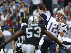 New England Patriots quarterback Tom Brady (12) passes under pressure from Oakland Raiders middle linebacker NaVorro Bowman (53) during the first half of an NFL football game Sunday, Nov. 19, 2017, in Mexico City. (AP Photo/Rebecca Blackwell)