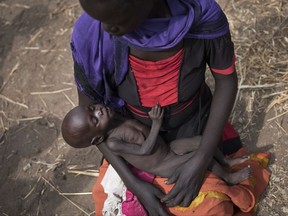FILE - In this Wednesday, April 5, 2017 file photo, Adel Bol, 20, cradles her 10-month-old daughter Akir Mayen at a food distribution site in Malualkuel, in the Northern Bahr el Ghazal region of South Sudan. In war-torn South Sudan 1.25 million people are facing starvation, double the number from the same time last year, according to a report by the United Nations and the government released Monday, Nov. 6th, 2017. (AP Photo, File)
