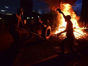 FILE - In this Monday, Oct. 30, 2017 file photo, residents demonstrate and burn tyres in the street after the election result was announced, in Kisumu, Kenya. While secession proposals by the opposition stand little chance of becoming reality, they reflect a growing sense of marginalization along ethnic lines in one of Africa's most influential nations. (AP Photo, File)