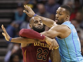 Cleveland Cavaliers' LeBron James (23) tries to break free of Charlotte Hornets' Dwight Howard (12) during the first half of an NBA basketball game in Charlotte, N.C., Wednesday, Nov. 15, 2017. (AP Photo/Chuck Burton)