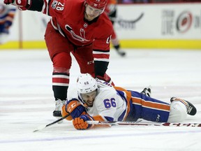 Carolina Hurricanes' Elias Lindholm (28), of Sweden, and New York Islanders' Joshua Ho-Sang (66) chase the puck during the first period of an NHL hockey game in Raleigh, N.C., Sunday, Nov. 19, 2017. (AP Photo/Gerry Broome)