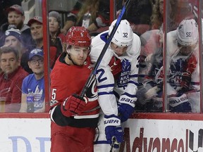 Carolina Hurricanes' Noah Hanifin (5) check Toronto Maple Leafs' Josh Leivo (32) during the first period of an NHL hockey game in Raleigh, N.C., Friday, Nov. 24, 2017. (AP Photo/Gerry Broome)