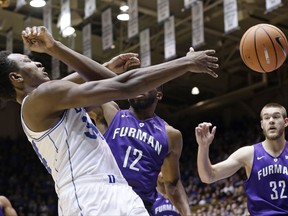 Duke's Wendell Carter Jr., left, and Furman's Devin Sibley (12) struggle for possession of the ball during the first half of an NCAA college basketball game in Durham, N.C., Monday, Nov. 20, 2017. Furman's Matt Rafferty (32) watches at right. (AP Photo/Gerry Broome)