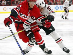 Carolina Hurricanes' Noah Hanifin (5) tangles with Chicago Blackhawks' Tommy Wingels (57) during the first period of an NHL hockey game, Saturday, Nov. 11, 2017, in Raleigh, N.C. (AP Photo/Karl B DeBlaker)