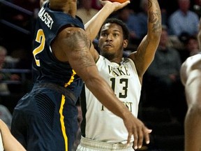 Wake Forest's Bryant Crawford shoots a 3-pointer over UNC Greensboro's Malik Massey during the first half of an NCAA college basketball game, Friday, Nov. 24, 2017, in Winston-Salem, N.C. (Walt Unks/Winston-Salem Journal via AP)