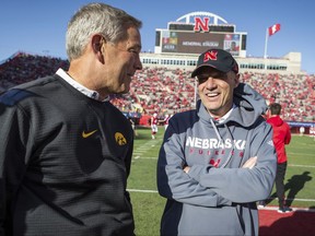 Iowa head coach Kirk Ferentz and Nebraska head coach Mike Riley meet at the center of the field during warm-ups prior to an NCAA college football game in Lincoln, Neb., Friday, Nov. 24, 2017. (AP Photo/John Peterson)