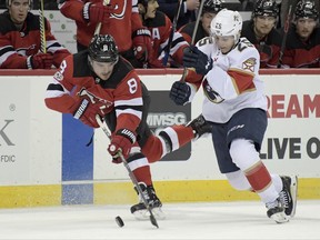 New Jersey Devils defenseman Will Butcher (8) skates with the puck as Florida Panthers left wing Henrik Haapala (25) defends during the first period of an NHL hockey game, Monday, Nov. 27, 2017, in Newark, N.J. (AP Photo/Bill Kostroun)