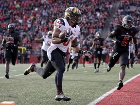 Maryland running back Ty Johnson, left, runs in for a touchdown after catching a pass from quarterback Max Bortenschlager, not pictured, as Rutgers linebacker Deonte Roberts, right, chases him during the first half of an NCAA college football game, Saturday, Nov. 4, 2017, in Piscataway, N.J. (AP Photo/Julio Cortez)