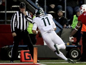 Michigan State running back Connor Heyward dives in for a touchdown after making a catch on a pass from quarterback Brian Lewerke, not pictured, during the first half of an NCAA college football game against Rutgers, Saturday, Nov. 25, 2017, in Piscataway, N.J. (AP Photo/Julio Cortez)