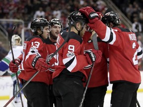 New Jersey Devils celebrate a goal by left wing Taylor Hall (9) during the second period of an NHL hockey game against the Vancouver Canucks, Friday, Nov. 24, 2017, in Newark, N.J. (AP Photo/Julio Cortez)