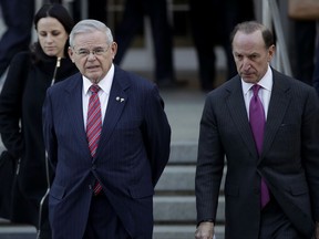 U.S. Sen. Bob Menendez, center, walks out of the Martin Luther King Jr. Federal Courthouse with his lawyer Abbe Lowell after U.S. District Judge William H. Walls declared a mistrial in Menendez's federal corruption trial, Thursday, Nov. 16, 2017, in Newark, N.J. (AP Photo/Julio Cortez)