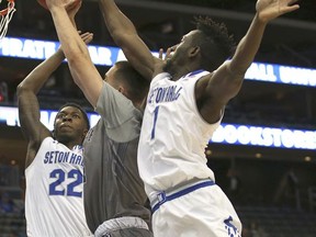 Monmouth's Louie Pillari (24) attempts a shot as Seton Hall's Myles Cale (22) and Michael Nzei (1) defends during the first half of an NCAA college basketball game in Newark, N.J., Sunday, Nov. 12, 2017. (AP Photo/Rich Schultz)