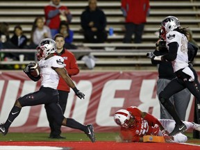 UNLV running back Lexington Thomas, left, scores a touchdown past New Mexico cornerback Jalin Burrell (13) during the first half of an NCAA college football game in Albuquerque, N.M., Friday, Nov. 17, 2017. (AP Photo/Andres Leighton)