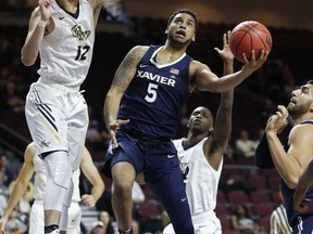 Xavier's Trevon Bluiett shoots around George Washington's Yuta Watanabe, left, during the first half of an NCAA college basketball game Thursday, Nov. 23, 2017, in Las Vegas. (AP Photo/John Locher)