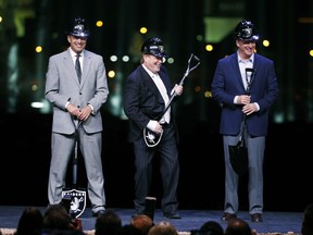Oakland Raiders owner Mark Davis, center, pretends to play air guitar beside Nevada Gov. Brian Sandoval, left, and NFL Commissioner Roger Godell during a ceremonial groundbreaking for the Raiders' stadium Monday, Nov. 13, 2017, in Las Vegas. After years of planning, dealing and getting millions in public financing approved, the team broke ground on a 65,000-seat domed stadium in Las Vegas, across the freeway from the city's world-famous casinos. (AP Photo/John Locher)