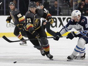 Vegas Golden Knights center William Karlsson (71) battles for the puck with Winnipeg Jets defenseman Jacob Trouba (8) during the second period of an NHL hockey game Friday, Nov. 10, 2017, in Las Vegas. (AP Photo/John Locher)