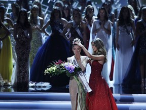 Former Miss Universe Iris Mittenaere, right, crowns new Miss Universe Demi-Leigh Nel-Peters at the Miss Universe pageant Sunday, Nov. 26, 2017, in Las Vegas. (AP Photo/John Locher)