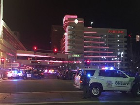 Police respond to an active shooter at a high-rise building of luxury condominiums in Reno, Nev., Tuesday, Nov. 28, 2017. A suspect is in custody after opening fire for at least 20 minutes Tuesday night, but there are no reports of any injuries, authorities said. The shots were fired at the Montage, a building in downtown Reno where SWAT teams and news vans have gathered. (Andy Barron/The Reno Gazette-Journal via AP)