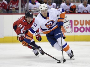 FILE - In this Nov. 2, 2017, file photo, New York Islanders center Mathew Barzal (13) skates with the puck against Washington Capitals center Evgeny Kuznetsov (92), of Russia, during the second period of an NHL hockey game in Washington. It's the best phrase a young NHL player can hear, even better than being told he's made the team. Get a place. Making the opening night roster is certainly an accomplishment, though it can be fleeting. The time-honored tradition of a coach or general manager giving a player permission to check out of the hotel and find a place to live means he's sticking around for a long time, if not the entire season. There's value in getting that message from an organization well before the 28-day mark, as Islanders rookie Barzal found out. "That kind of just made me comfortable, just knowing I have an opportunity to be here for a little while or they like what I've been doing so far," said Barzal. (AP Photo/Nick Wass, File)