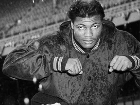 FILE - In this Dec. 29, 1956, file photo, Chicago Bears' J.C. Caroline runs through falling snow after the weather cancelled NFL football practice at Yankee Stadium in New York. Caroline, a star University of Illinois running back in the 1950s who played for the Chicago Bears for a decade, died Friday at Carle Hospital in Champaign, Ill, officials with Walker Funeral Home said. He was 84. (AP Photo/John Lindsay, File)