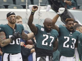 FILE - In this Oct. 8, 2017, file photo, Philadelphia Eagles' Chris Long (56), Malcolm Jenkins (27) and Rodney McLeod (23) gesture during the National Anthem before an NFL football game against the Arizona Cardinals, in Philadelphia. Baltimore's Ben Watson and Philadelphia's Malcolm Jenkins have strong views toward anthem protests and those who oppose them, based on their religious beliefs. But even pastors can't agree on the controversial topic that has enveloped the NFL this season. (AP Photo/Matt Rourke, File)