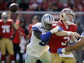 FILE - In this Sunday, Oct. 22, 2017, file photo, San Francisco 49ers quarterback C.J. Beathard (3) fumbles as he is hit by Dallas Cowboys defensive end Demarcus Lawrence during the first half of an NFL football game in Santa Clara, Calif. Lawrence leads the NFL 10 and half sacks. (AP Photo/Eric Risberg, File)