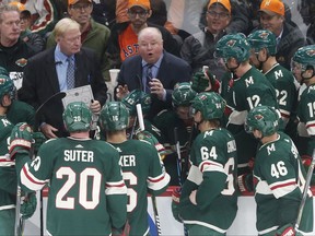 FILE - In this Oct. 31, 2017, file photo, Minnesota Wild coach Bruce Boudreau, center, talks to players during a timeout in the teams NHL hockey game against the Winnipeg Jets in St. Paul, Minn. Boudreau, whose Wild are 13th in the West but just two points out of a playoff spot, doesn't think much about the Thanksgiving rule. "If you look at it as this is a truism and you're not in at that time, you have a tendency to (think), 'Aw man, we're not going make it,' and I don't want anybody on our team thinking along those lines," Boudreau said. "But it's going to be close. Everybody's 8-9, 9-8, 10-9, 9-10." (AP Photo/Jim Mone)